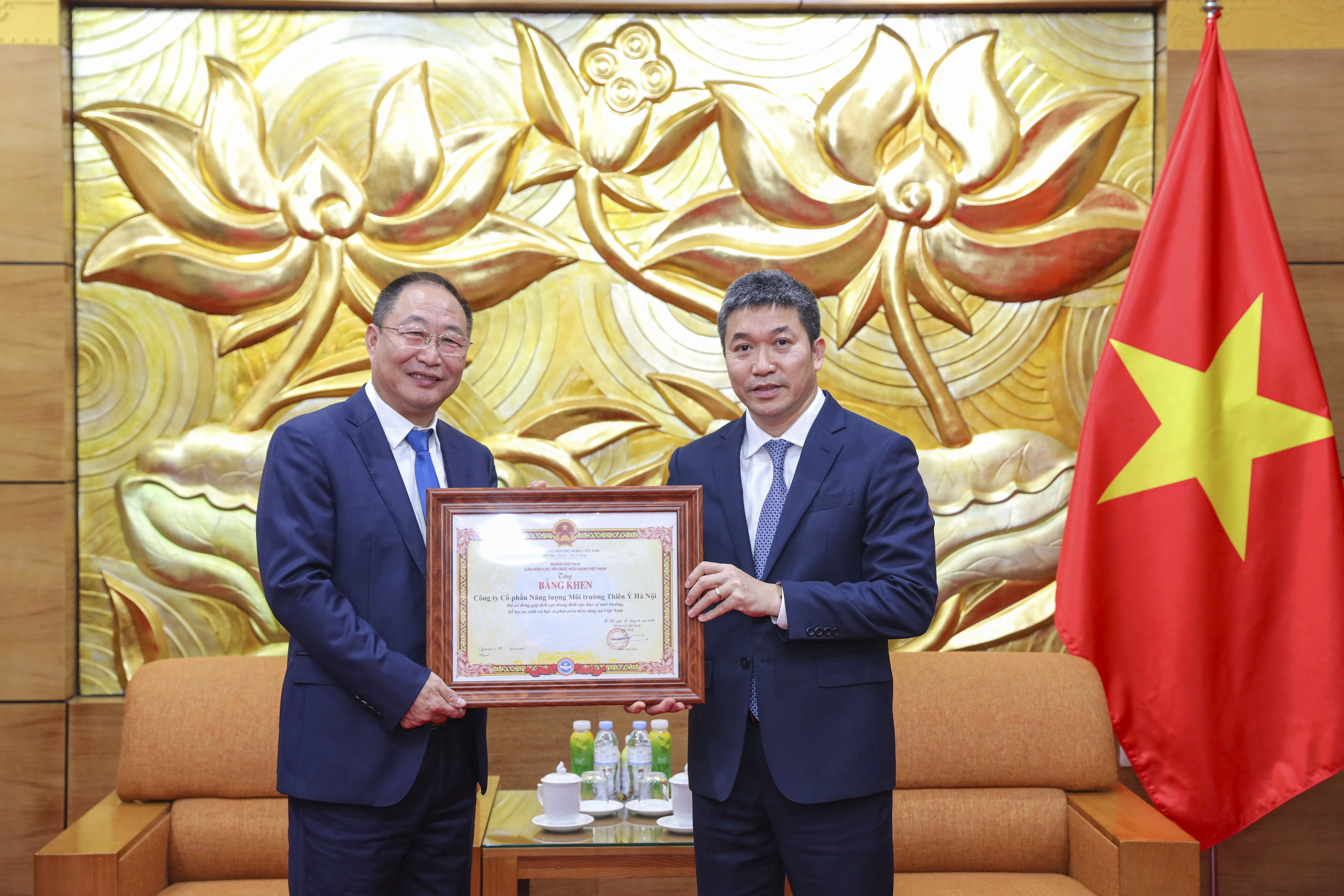 越南友好组织联合会主席潘英山向河内天禹环保能源股份公司代表颁发荣誉证书。（图：丁和 摄）
