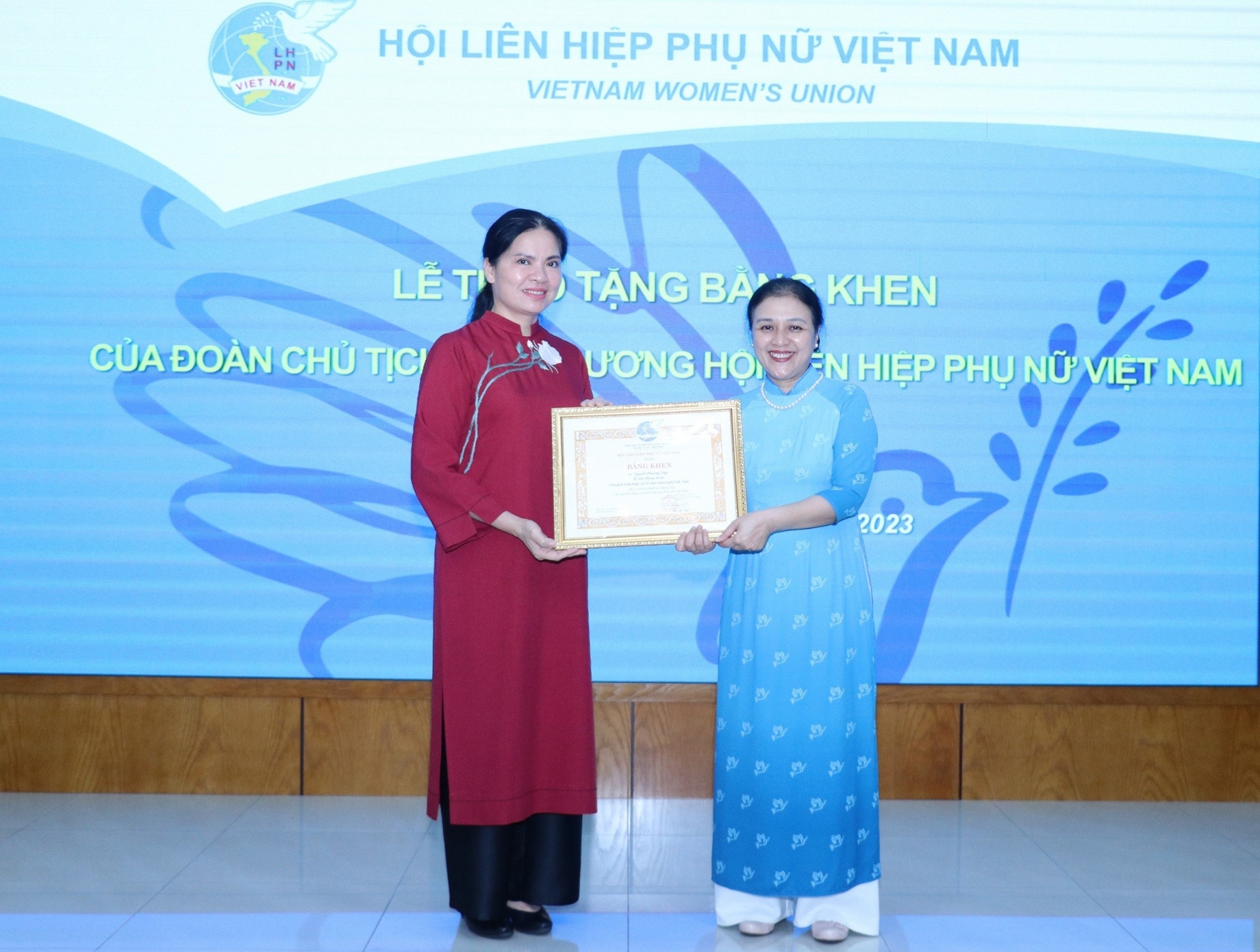 越南妇女联合会主席何氏娥（左边）向越南友好组织联合会主席阮芳娥颁发中央委员会的荣誉证书。