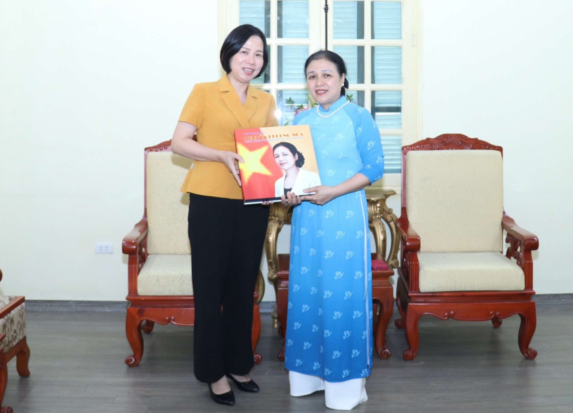 越通社社长武越庄（左边）向阮芳娥大使赠送《阮芳娥外交家——越南智慧和本领之旅》的画册。