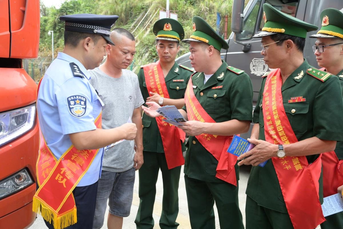 谅山省新清边防站官兵与中国坡寨边防检查站的职能部门合作，向边境居民发放法律宣传单。(图：李一 摄)