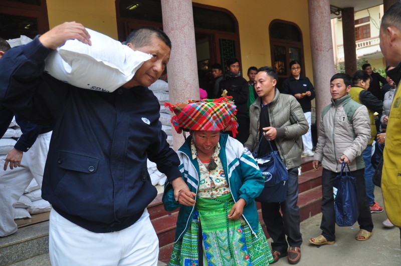 Ông Chen Ta Yu (bìa trái) phát quà Tết cho bà con huyện Trạm Tấu, tỉnh Yên Bái (nay là xã Trạm Tấu, tỉnh Lào Cai) ngày 13/01/2020. (Ảnh: Tzu Chi)