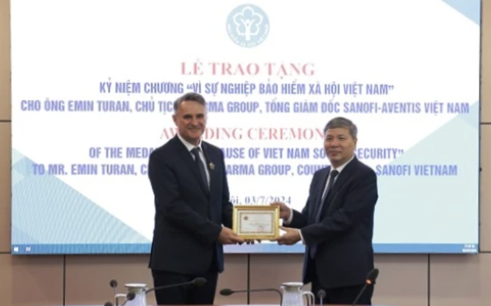 阮德和副总经理授予艾敏·图兰先生“致力于越南社会保险事业”纪念章。