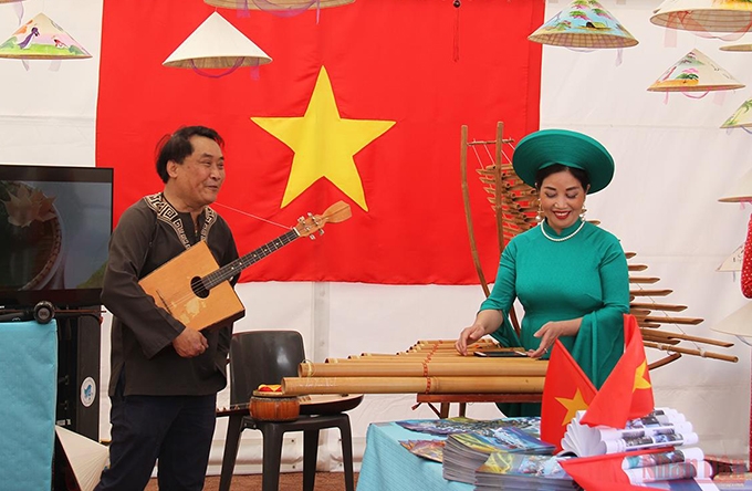 法国越南文化中心的艺术家在越南展位表演民族乐器。
