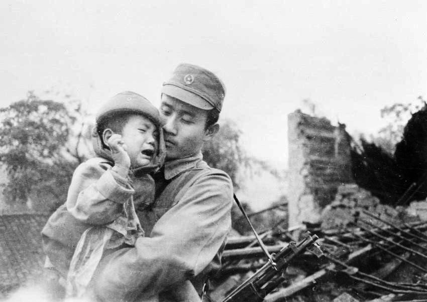 边防军战士吴维绒迅速从废墟中救出一名孩子。（图：吴庭福/越通社）