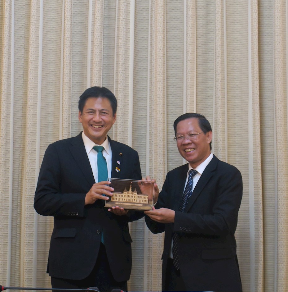 胡志明市人民委员会主席潘文买向日本外务副大臣武井俊辅赠送留念品。