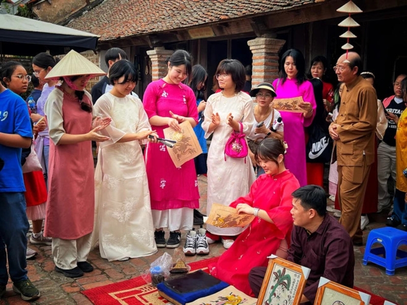日本游客团在新春庆祝活动中了解东胡画。 （图：梅梅）
