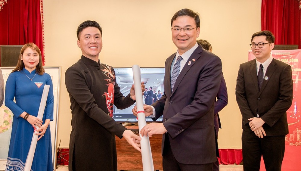 越南驻日本特命全权大使、外交部副部长范光号（右）向福冈越南人协会代表赠送越南地图。