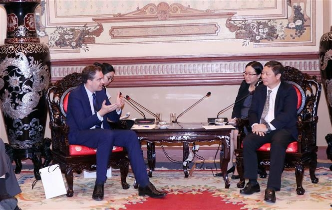 胡志明市人民委员会副主席杨英德（右一）与法国外贸事务部长奥利维尔·白赫特交谈。