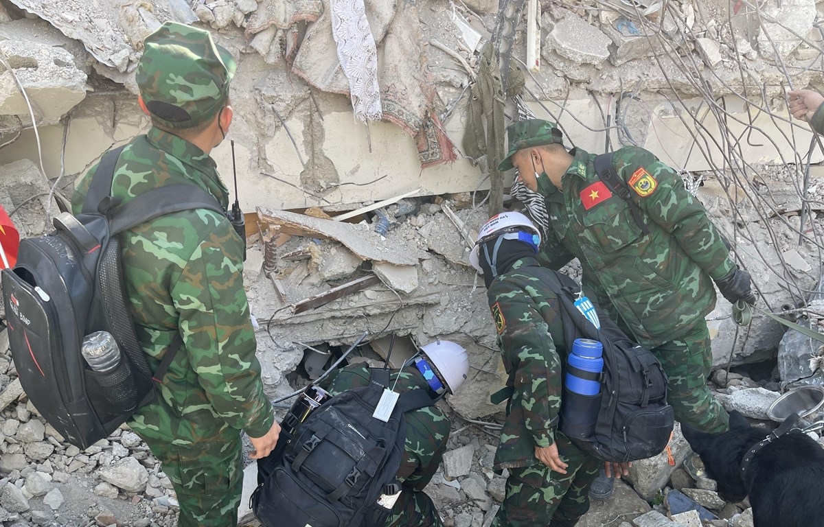 越南人民军救援救援部队在土耳其哈蒂省首府安塔基亚使用装备和嗅探犬追捕遇难者。