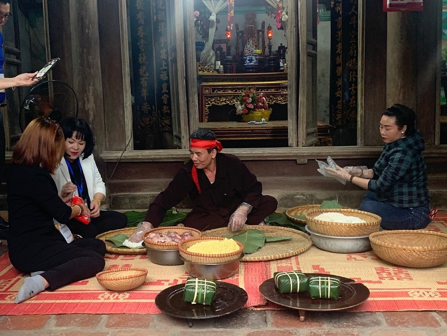 侨参加了与雄泸古村村民一起包粽子的体验活动。