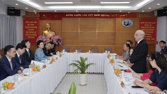胡志明市市委宣教部部长潘阮如奎向中共中央宣传部副部长张建春赠送鲜花。（图：黄雄）