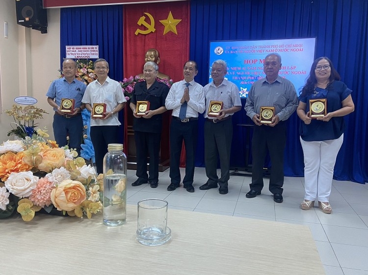 胡志明市海外越南人委员会副主任陈德贤先生向各个时期的领导人赠送礼物。
