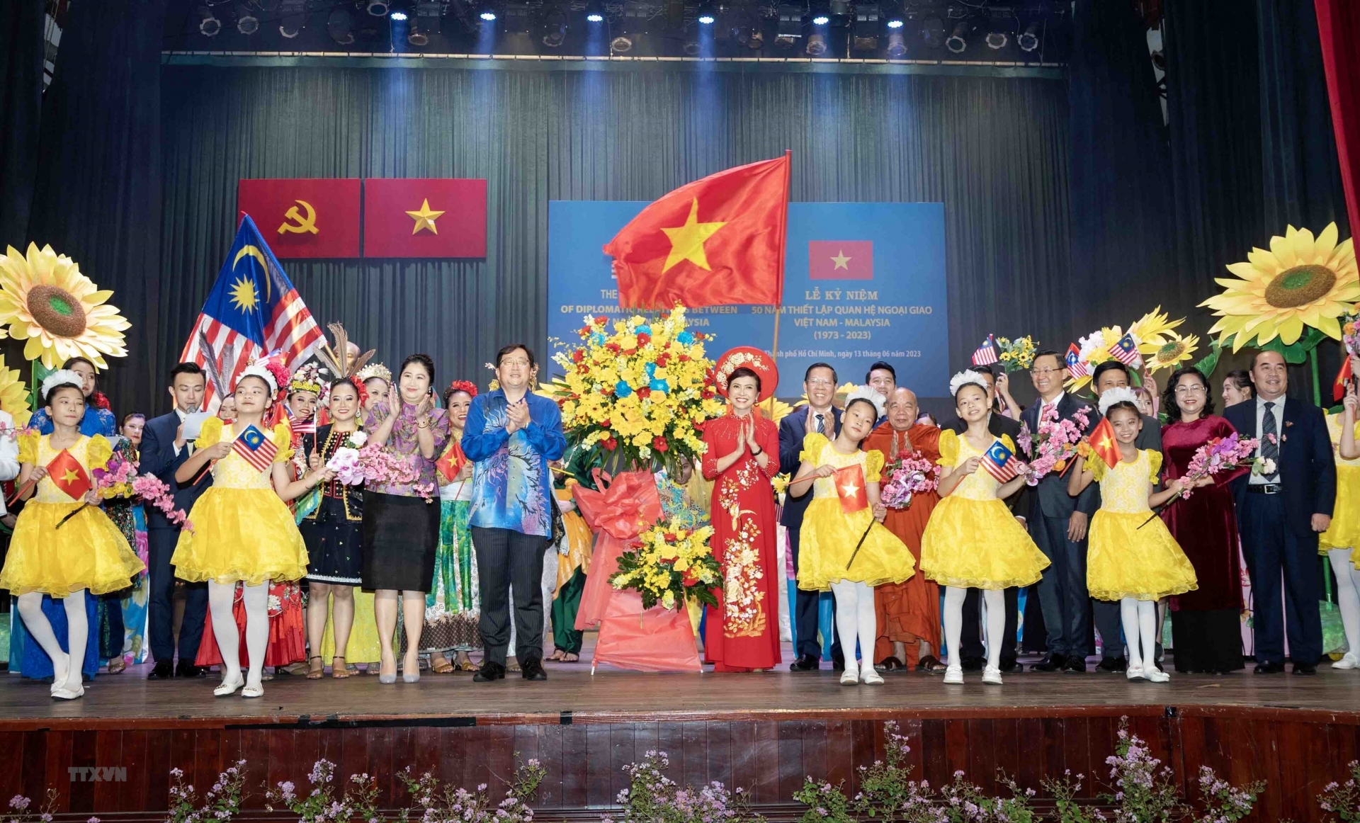 胡志明市人民委员会主席阮文买和马来西亚驻越南大使陈扬泰向在庆典上表演的艺术家们送花。