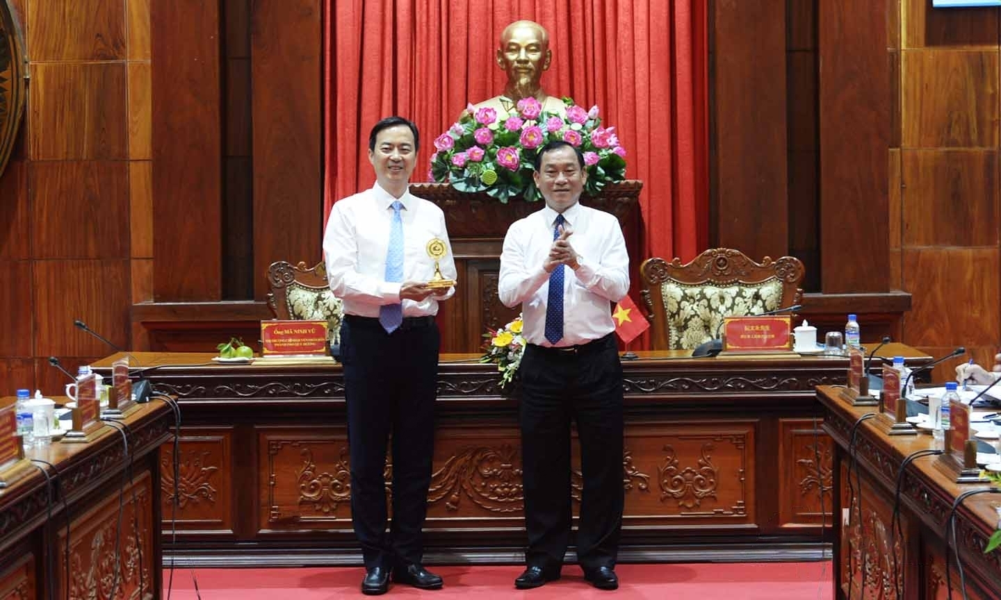 前江省人民委员会主席阮文永（右）向贵阳市市长马宁宇赠送该省标识。