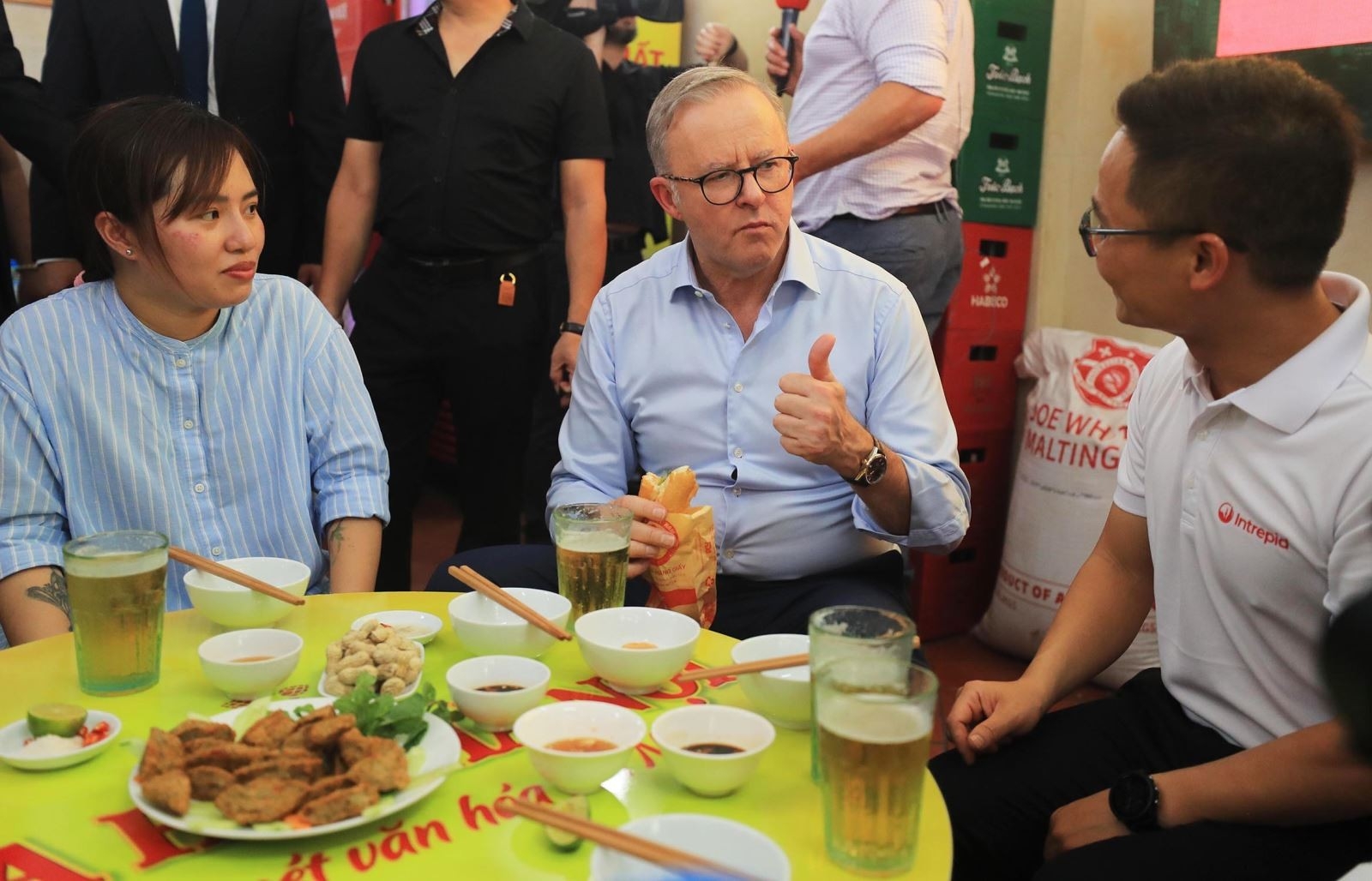 2023 年 6 月，澳大利亚总理安东尼·阿尔巴内斯访问越南期间，在人行道上品尝面包、喝啤酒。（图：越通社）