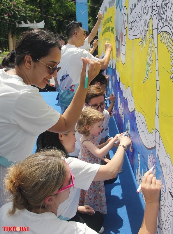 参加家庭预防溺水日的代表和孩子们为主题图着色。 这幅画将于7月22日至23日在统一公园展出。（图：洪英）