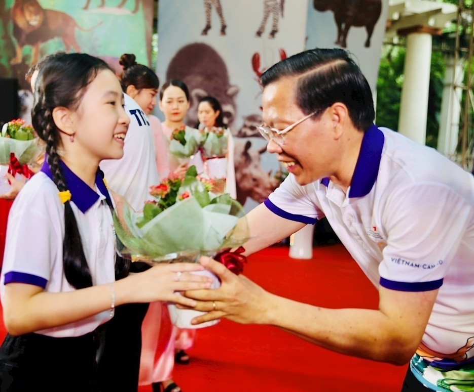 胡志明市人民委员会主席潘文买向该市越南和加拿大模范学生赠送长寿花盆栽。（图：www.hcmcpv.org.vn）