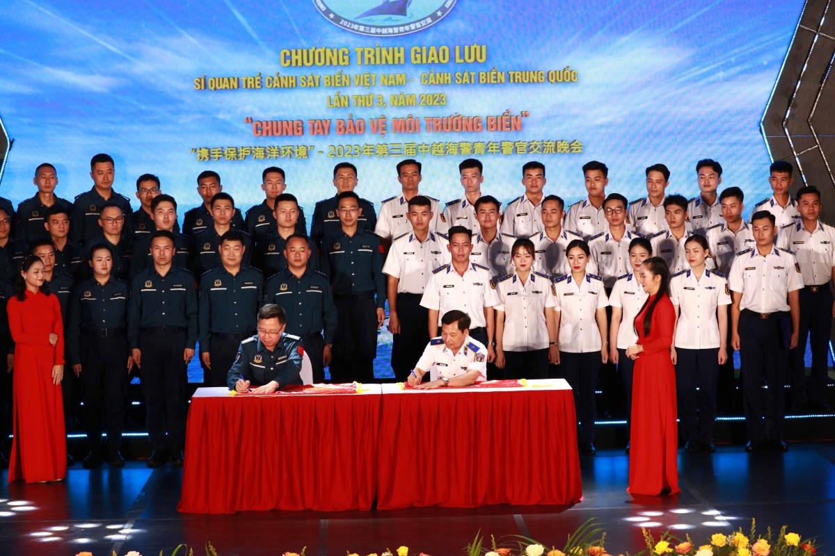 两国海警青年警官代表团团长在横幅上签名，表达了“携手保护海洋环境”的决心和承诺，培育越中团结友谊。（图：洪发）