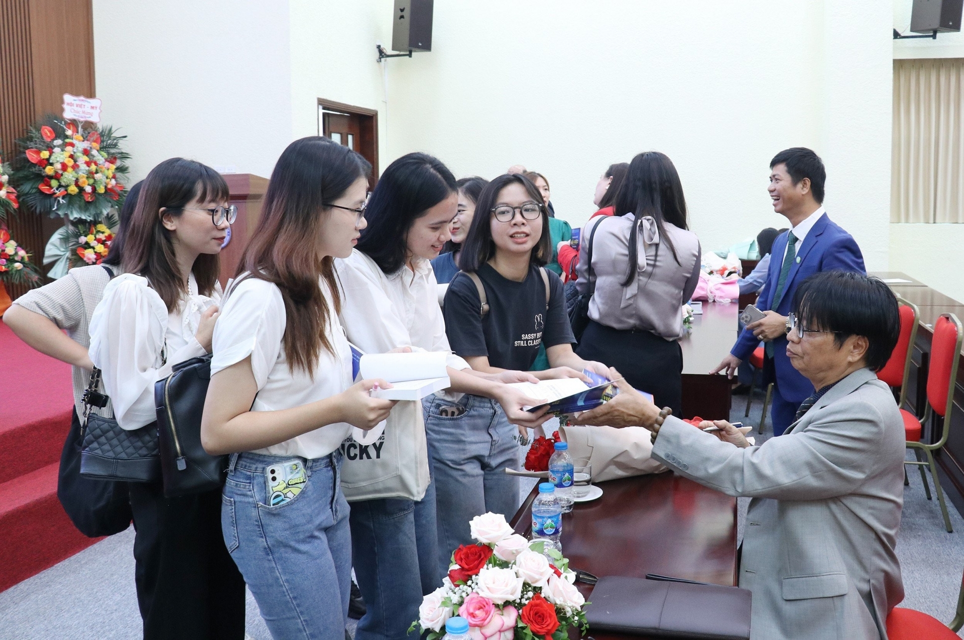 越南-巴西友好合作协会主席阮文凉博士为河内大学葡萄牙语系大学生签名赠《葡越词典》。