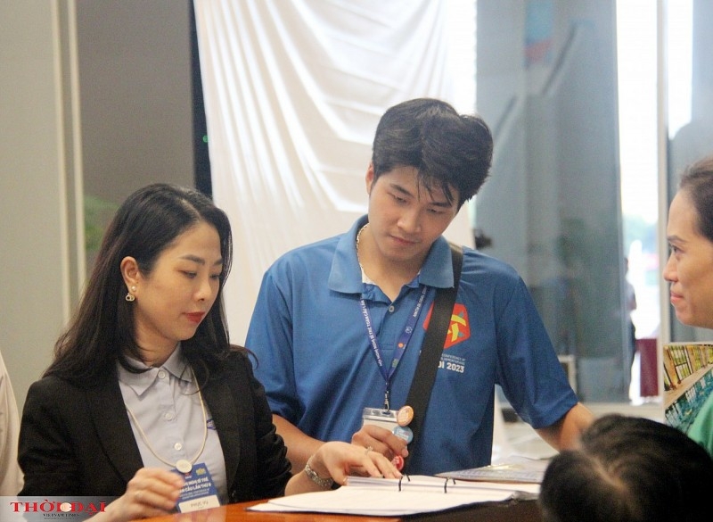 志愿者陈贵仁在展会上协助代表们与展位业主交谈（图：洪英）