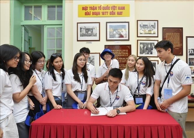越南青年侨胞代表团参观越南祖国阵线博物馆的传统展示区并写下留言。（图：明德/越通社）