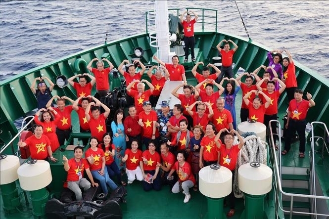 来自世界17个国家的40余名海外侨胞探访长沙群岛军民和DK1海上高脚屋。（资料图：叶张/越通社）