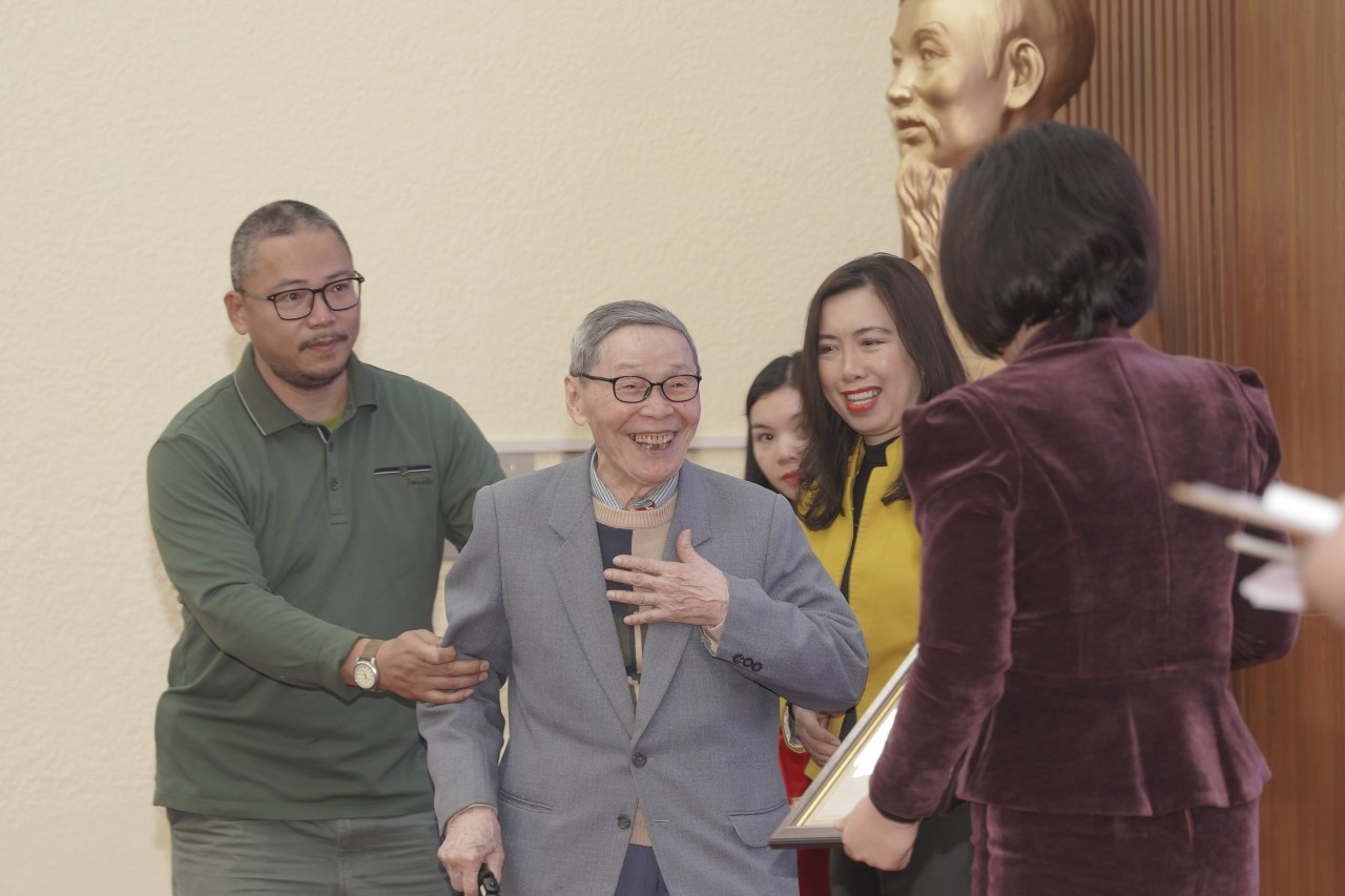 老挝前越南军事专家陶文进（左二）凭借《白刃——抗战中越南士兵的朋友》作品获得了二等奖，在 登上领奖台时，他难掩喜悦之情。