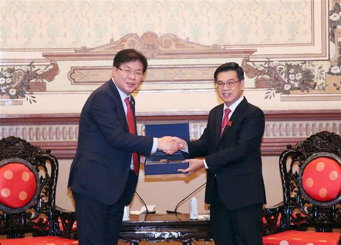 胡志明市人民议会副主席阮文勇（右）与韩国釜山市议会议长安成敏。