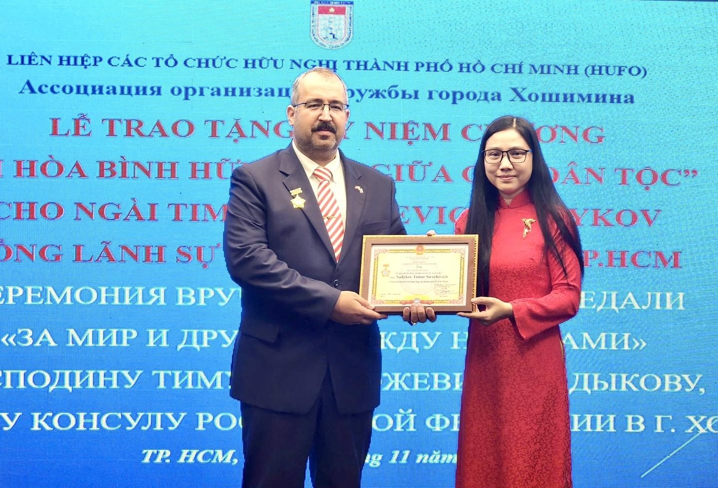 胡志明市友好组织联合会主席何青女士在纪念俄国十月革命108周年（1917年11月7日 - 2025年11月7日）见面会活动中，向俄罗斯联邦驻胡志明市总领事帖木儿·西罗泽维奇·萨德科夫（Timur Sirozevich Sadykov）先生授予“为各民族和平友谊”纪念章。（图片：HUFO）
