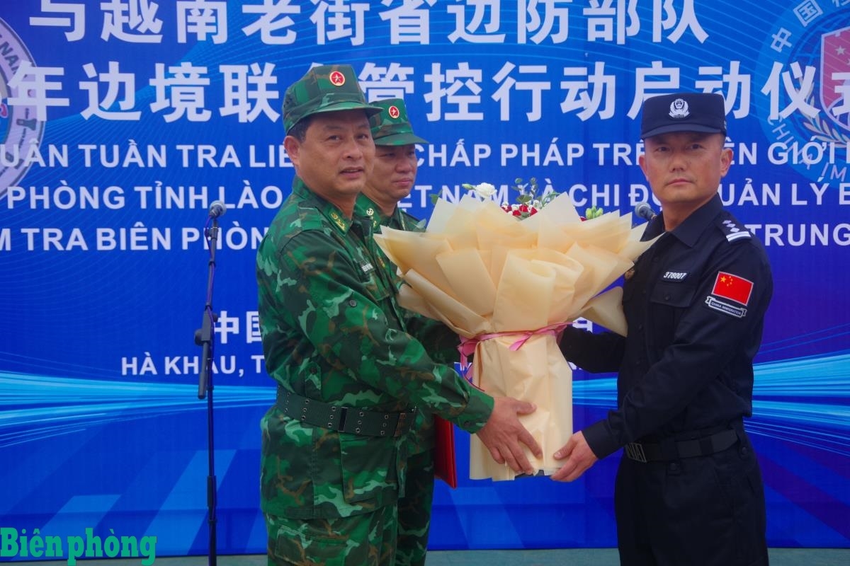 越南老街省边防部队联合巡逻指挥部领导与中国云南省红河边境管理支队联合巡逻指挥部领导在边界分界线处互赠鲜花。——摄影:忠勇 越南老街省边防部队联合巡逻指挥部领导与中国云南省红河边境管理支队联合巡逻指挥部领导在边界分界线处互赠鲜花。——摄影:忠勇