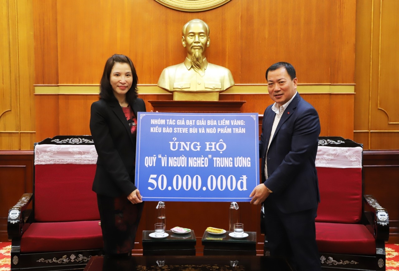 海外越南人侨务司副司长邓青芳在河内接收了《金锤镰奖》作家小组的捐款。