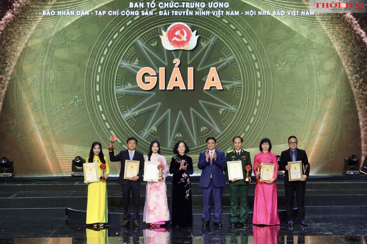 越南政府总理范明政和中央书记处常务书记张氏梅向得奖的作者、小组送奖项。