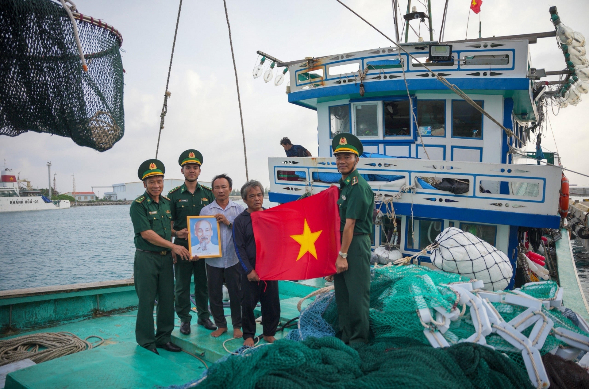 长沙岛边防站干部向长沙岛海上渔民赠送胡伯伯画像和国旗