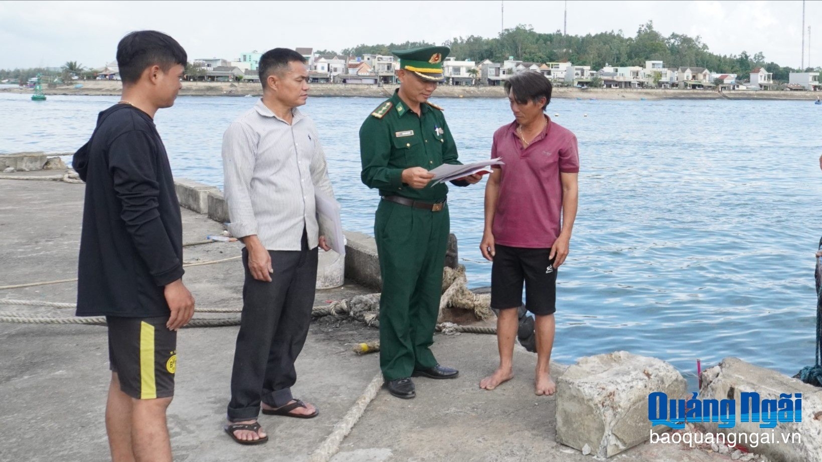 沙岐 (Sa Kỳ) 边防检查站干部在允许渔船离港前核对船员名单。（图：广义报）