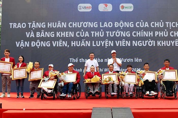 越南劳动、荣军与社会部副部长阮文回与组委会向优秀的残疾运动员颁发国家主席劳动勋章和政府总理的奖章。