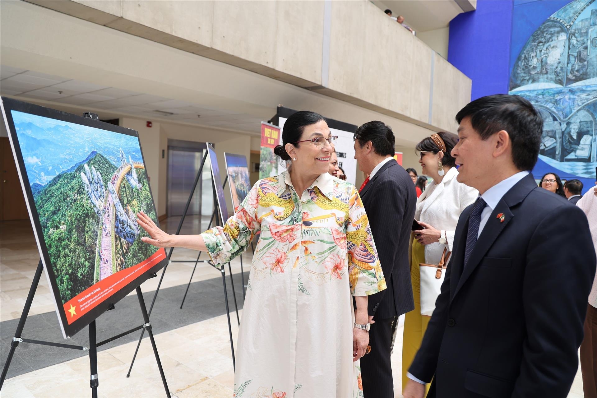 墨西哥众议长马塞拉·格拉·卡斯蒂略与越南驻墨西哥大使阮横年参观越南风土人情图片展。