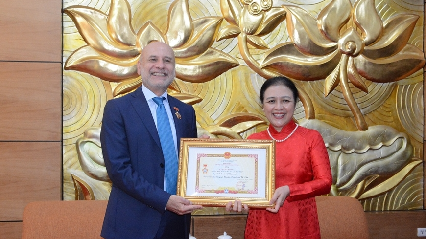 越南友好组织联合会主席阮芳娥大使向意大利驻越南大使安东尼奥·亚历山德罗授予“致力于各民族和平与友谊”纪念章。