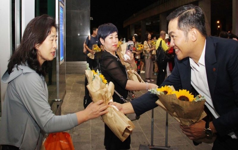 优胜者 (Winner) 国际旅行（越南）有限公司经理何俊明向国际游客团送鲜花表示欢迎。