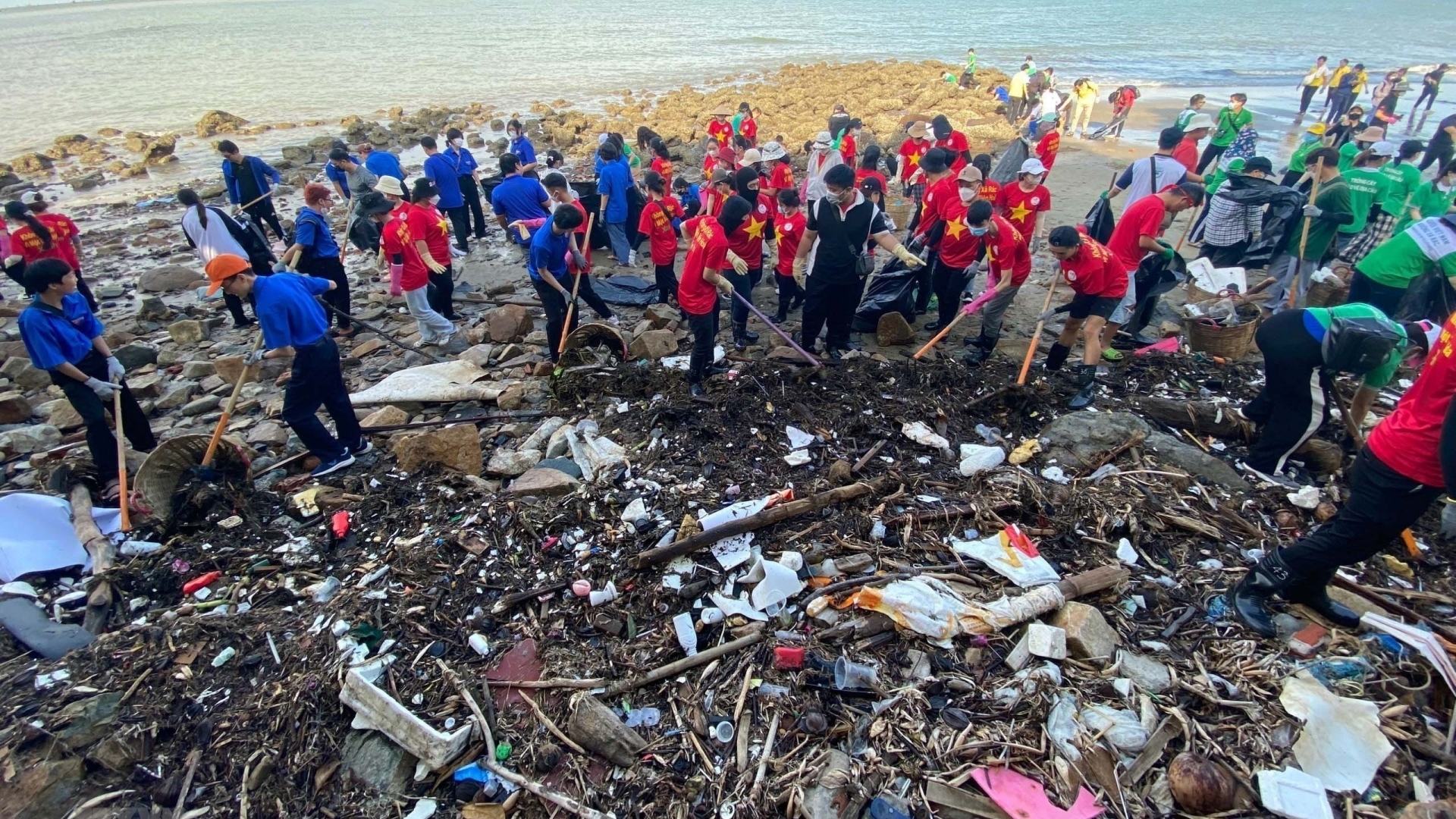 志愿者和游客参与清理海滩垃圾活动