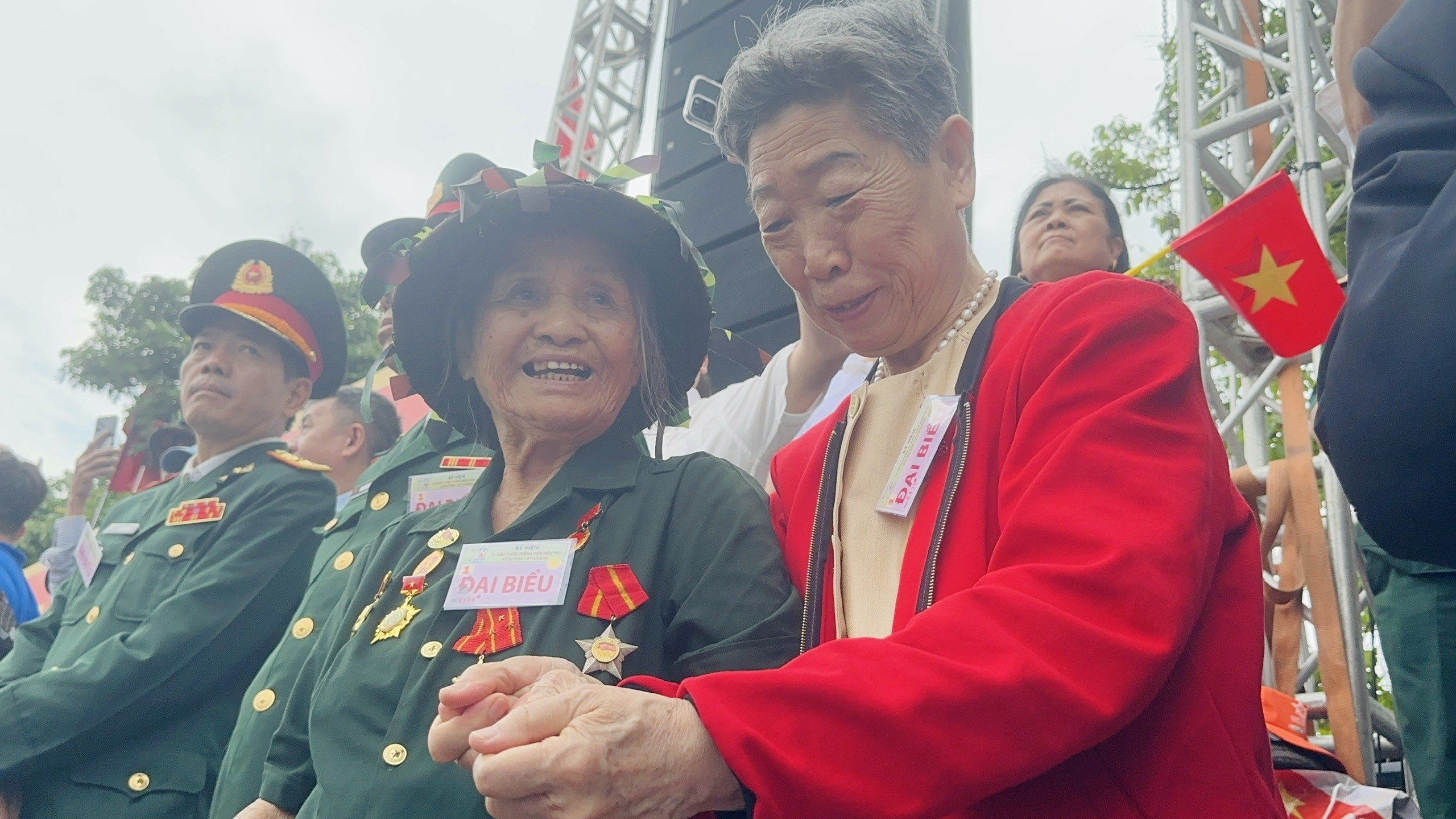 2024年，在越南举行的奠边府大捷70周年纪念活动上，由于天气寒冷多雨，于淑慧女士体贴地为身旁的一位老兵代表搓手取暖。