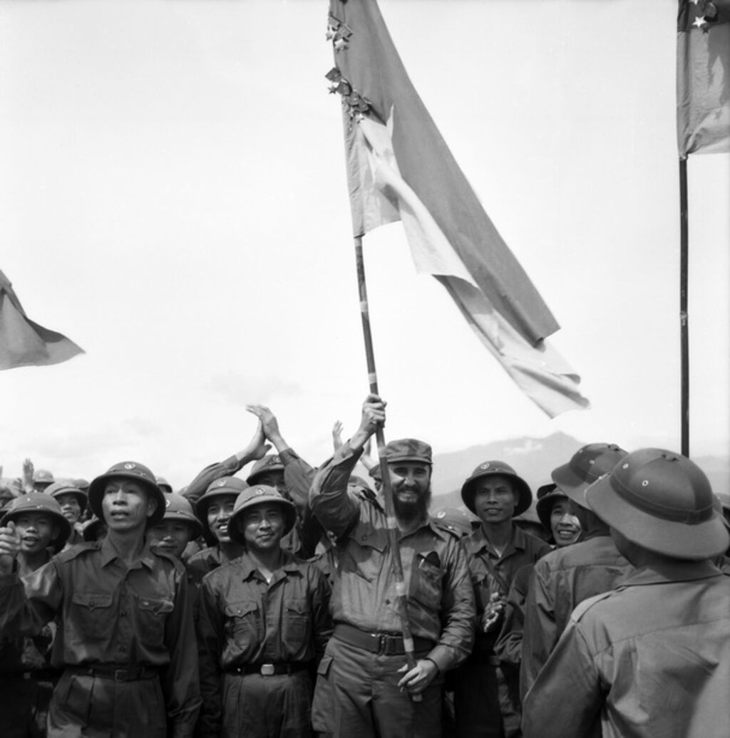 菲德尔·卡斯特罗同志高举上面挂着闪闪发光的治天-顺化解放军溪生团勋章的百战百胜旗帜。