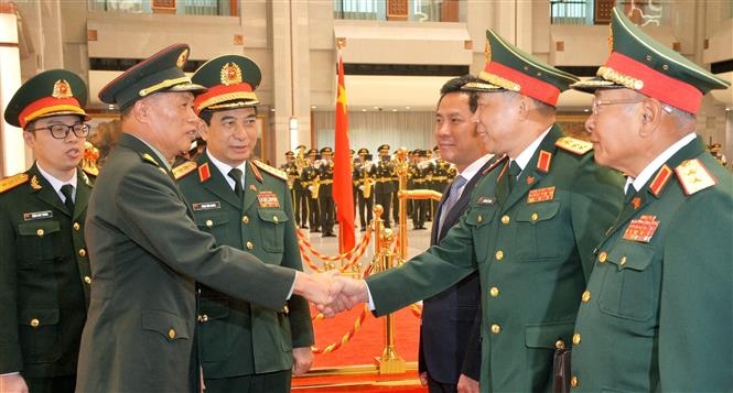 中共中央政治局委员、中共中央军事委员会副主席何卫东上将同越南代表亲切握手。