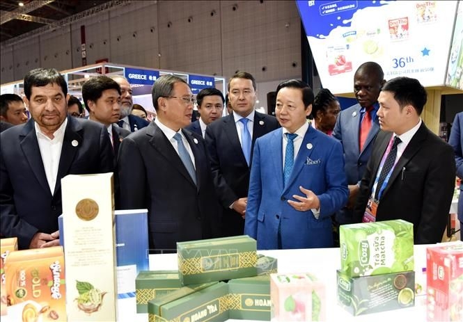 越南政府副总理陈红河在越南展位向中国总理李强及各位嘉宾介绍越南的优质商品。