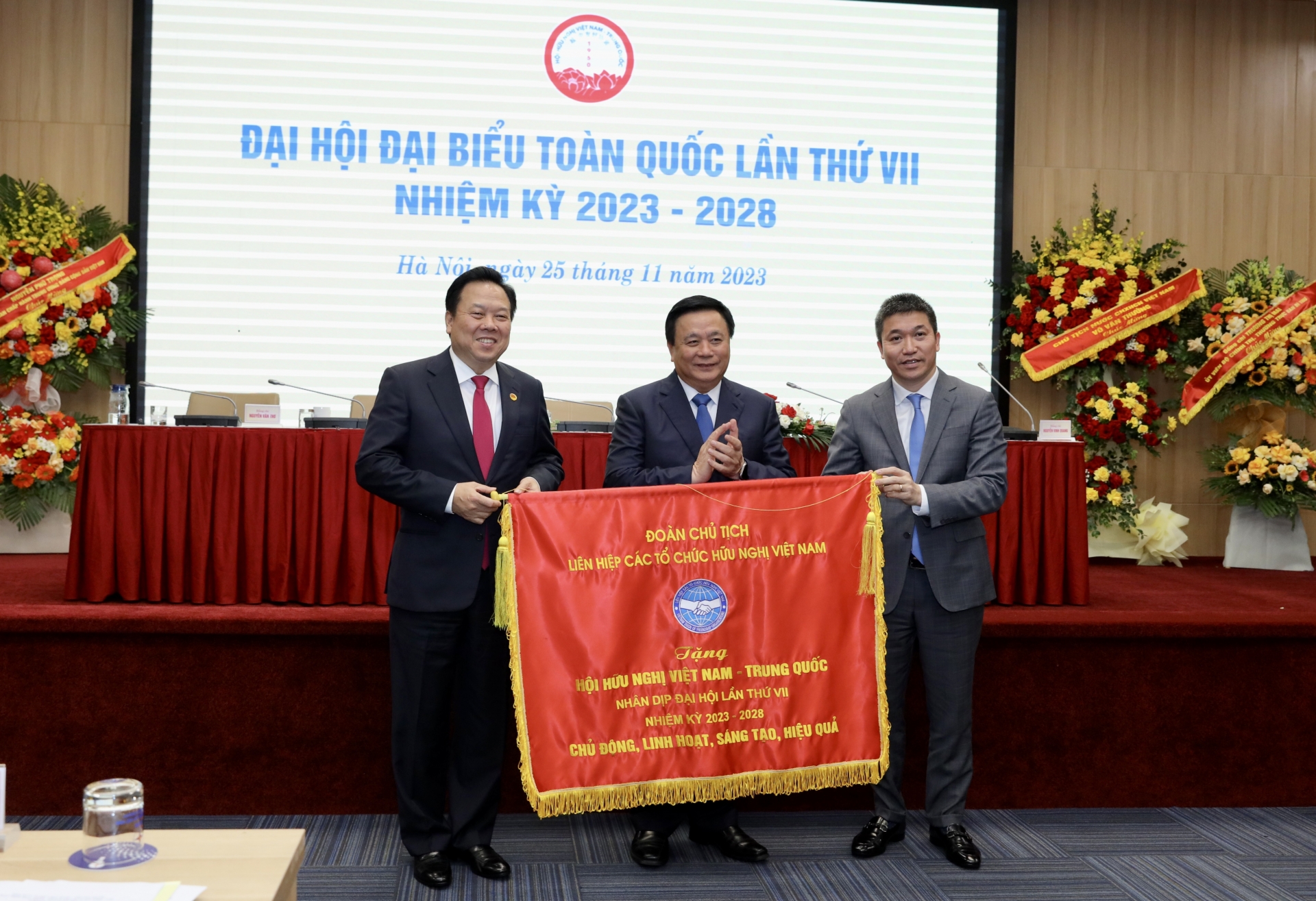 越南友好组织联合会主席潘英山（右）向越中友好协会赠送纪念旗。