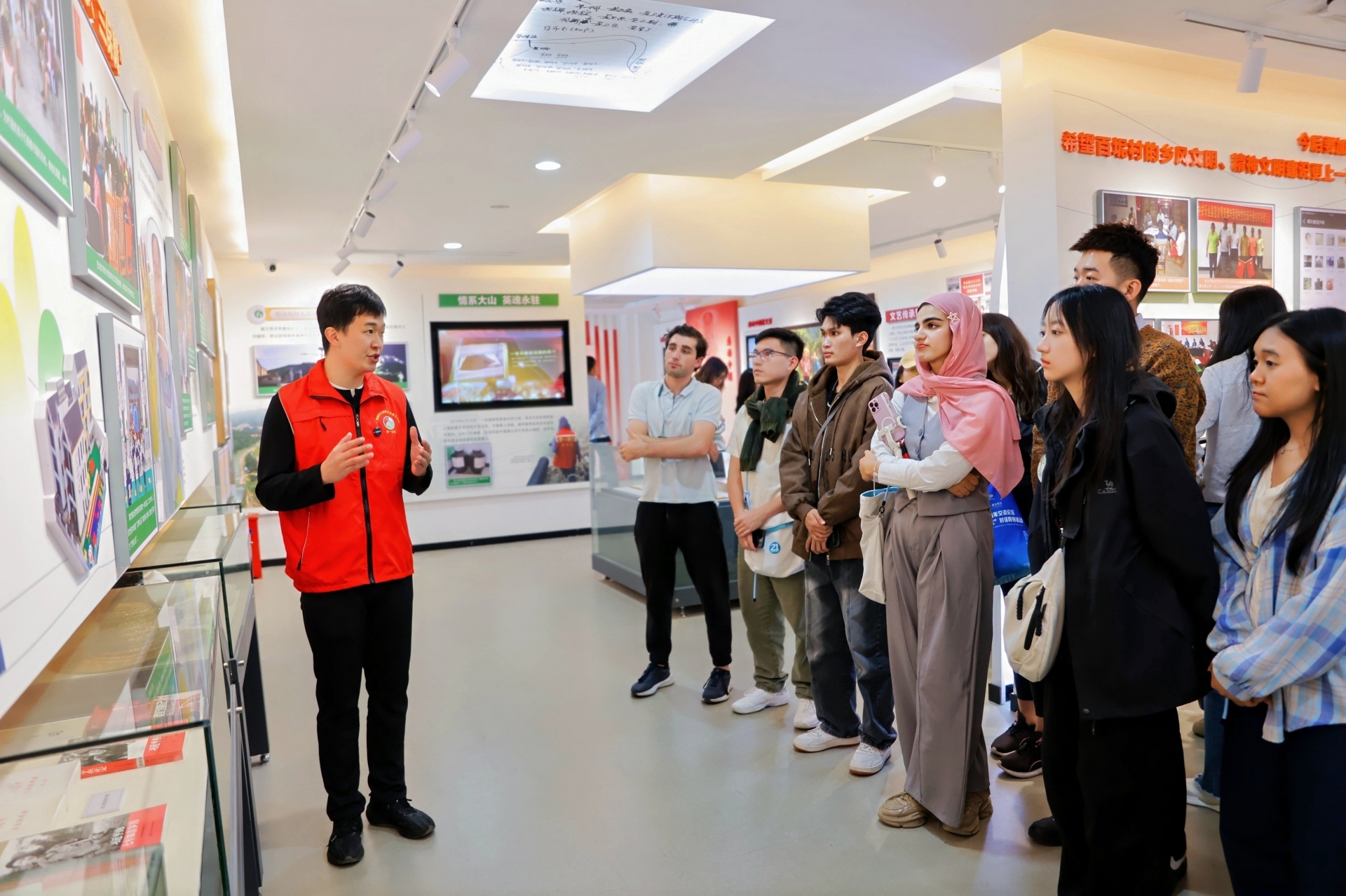 海外青年在百坭村深入了解黄文秀的先进事迹，被她投身脱贫攻坚的奉献精神深深打动。