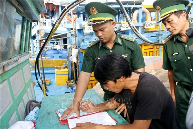 青海边防屯干部指导渔民签署不违反IUU承诺书。(图片:越通社) 青海边防屯干部指导渔民签署不违反IUU承诺书。(图片:越通社)